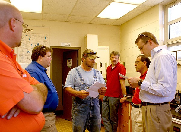 Larry Buffer, Gravette wastewater plant operator, explains recent test results with ADEQ officials on the right, Ryan Benefield, Moe Shafi and John Bailey. Council member John Rambadt and Mayor Byron look on.
