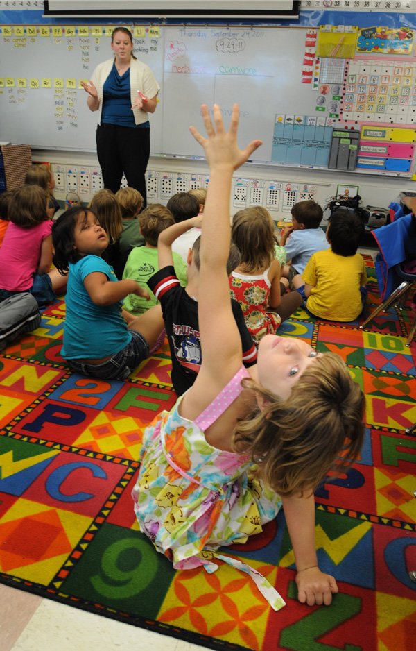 Jordan Herzberg, Root Elementary School first-grader, raises her hand to ask a question Thursday as assistant teacher Cory White talks about herbivores, carnivores and omnivores during a science lesson in Fayetteville.