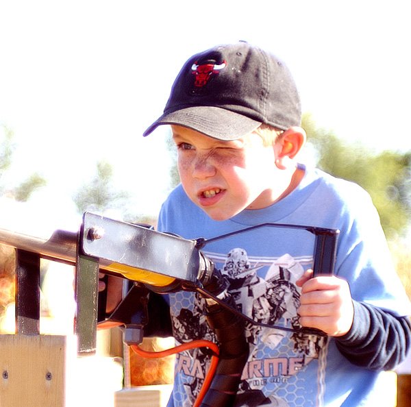 Taking Careful Aim — Jamie Holt, 7, of Gentry, takes aim at downfield targets with an air cannon at the Bloomfield Corn Maze on Sunday. Holt, with his mom and siblings, enjoyed the afternoon, going through the hay maze, riding on a horse-drawn wagon and participating in other games and activities. For more photographs and information on the maze, see Page 8B.