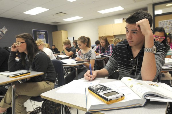 Manuel Marrero, right, a Rogers High School student, listens during a math lesson Tuesday. At left is student Whitney Hendrix. The high school added more math and science classes because of an enrollment increase.