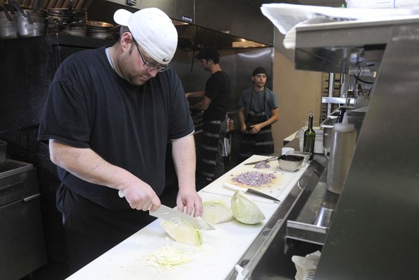FILE Chef Rob Nelson cuts cabbage at Tusk & Trotter American Brasserie in downtown Bentonville while preparing a special menu for an Oktoberfest event. The chef was named the runner-up on the Food Network show Guy's Grocery Games.
