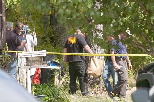 Members of the Saline Co., Sheriffs Office, the Benton Police Department and the FBI investigate the scene were the remains of two people were found behind a house located at 2502 W. Main Street in Traskwood on Wednesday.  
