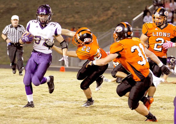 Gravette's Jordan Lundholm reaches to make the tackle against Ozark's Asher Ree in play in Gravette on Friday. Tyler Greenhaw moves into position to assist. Kelton McDougal is in the background to the right.
