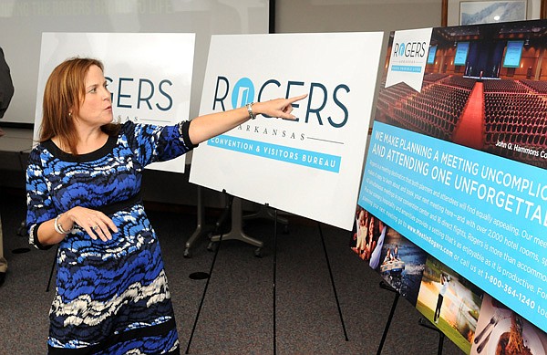 Melissa Thoma speaks at a media luncheon Tuesday at the Rogers-Lowell Chamber of Commerce about the features she and her husband Martin Thoma incorporated into the new logo for the Rogers. The firm of ThomaThoma began working on the logo and its tagline “Rogers, Arkansas — Where Possible Lives” in early March.
