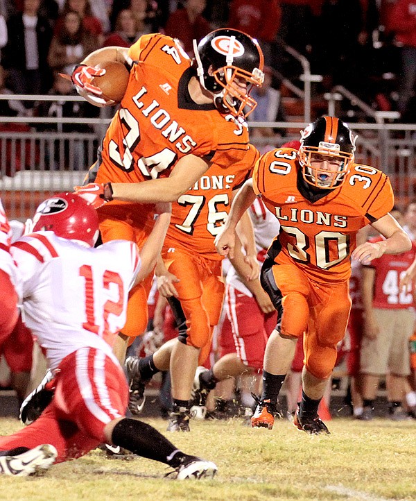 Photo by Heather Brody
Gravette senior Dallas Kerley, assisted by junior Brenton Ogle, attempts to pick up yards for Gravette in play against Farmington on Friday.
