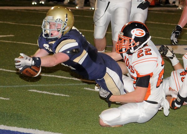 Chris Cox, running back for Shilon Christian, left, dives to score against Gravette in the second quarter in Springdale on Friday. Gravette’s Jordan Lundholm tried to make the tackle.
