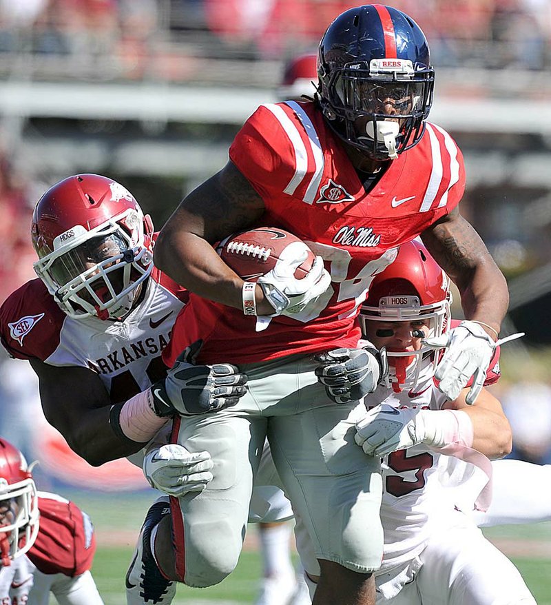 Arkansas defenders Chris Smith (left) and Ross Rasner try to bring down Mississippi running back Brandon Bolden during Saturday’s game at Vaught-Hemingway Stadium in Oxford, Miss. The Razorbacks got off to a slow start, and trailed the Rebels 17-0 before finally finding their rhythm. 