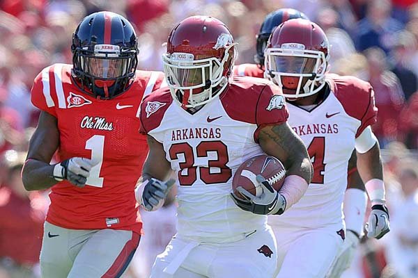  Arkansas running back Dennis Johnson (33) tries to outdistance Mississippi defender Damien Jackson (1) during a second-quarter 52-yard run for the Razorbacks’ first touchdown in a 29-24 victory over the Rebels in Oxford, Miss., on Saturday. 