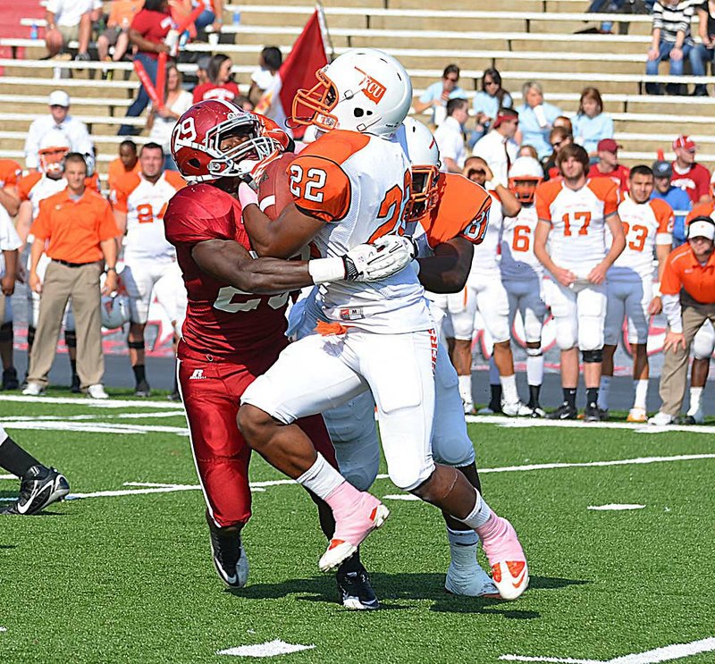  Henderson State linebacker Benny Anderson (left) collides with East Central (Okla.) running back Titus Mobley during the Reddies’ 42-41 victory Saturday. 