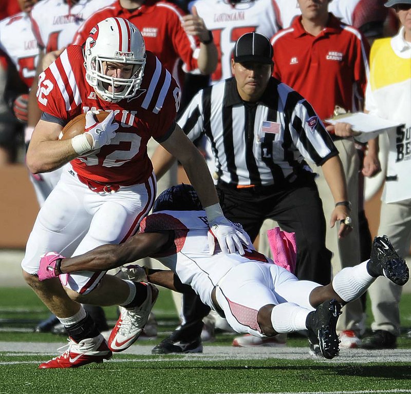 Western Kentucky tight end Jack Doyle is brought down by Louisiana-Lafayette cornerback Dwight Bentley during the Hilltoppers’ 42-23 victory Saturday in Bowling Green, Ky. 