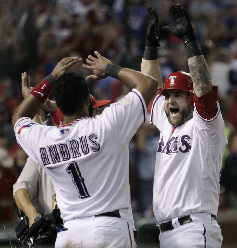 Texas Rangers catcher Mike Napoli (right) celebrates with teammates Yorvit Torrealba (8) and Elvis Andrus (1) after hitting a three-run home run during the sixth inning of Sunday’s game in Arlington, Texas. 