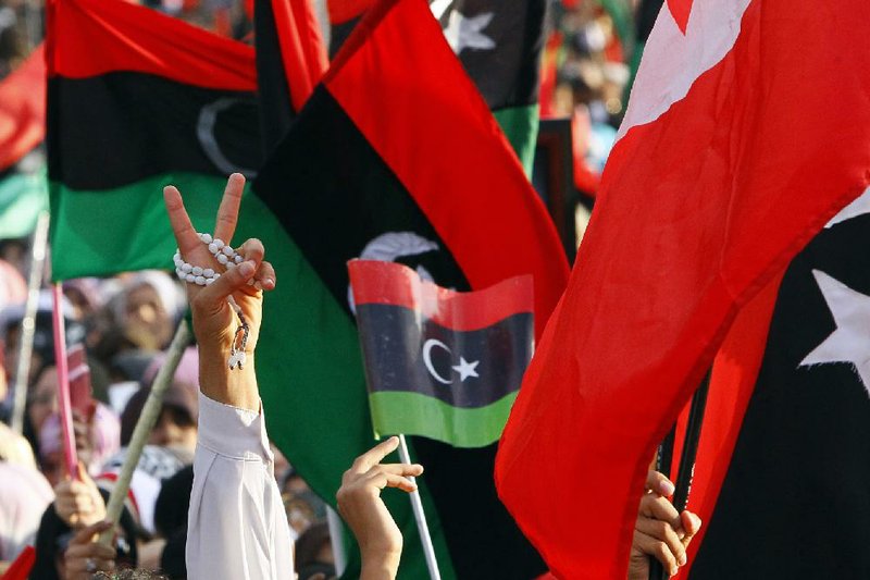 A Libyan flashes the victory sign to celebrate at Saha Kish Square in Benghazi, Libya, on Sunday as the transitional government declared liberation of the nation after months of bloodshed. 