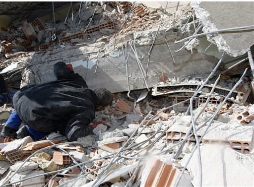 A man looks for family members in the debris of a collapsed building in eastern Turkey on Monday, Oct. 24, 2011. 