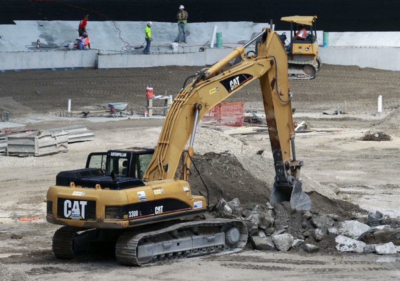 A Caterpillar excavator works at the new Florida Marlins baseball park in Miami in September. Caterpillar on Monday reported third-quarter earnings of $1.14 billion, or $1.71 per share. 