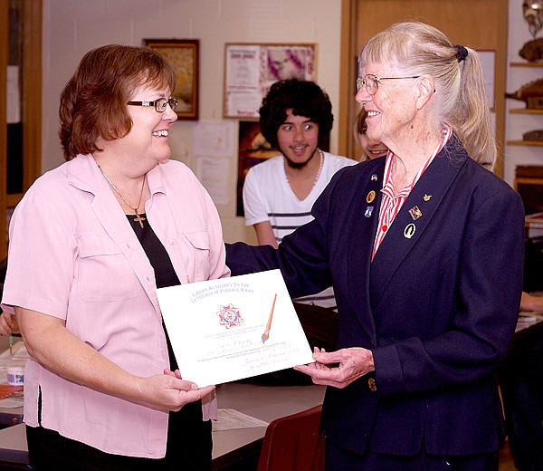 Lynn Garside, left, art teacher at Gentry High School, received an award from Dixie Grimes, president of the local V.F.W. Ladies Auxiliary, for her contributions as a teacher to the patriotic art contests held each year.
