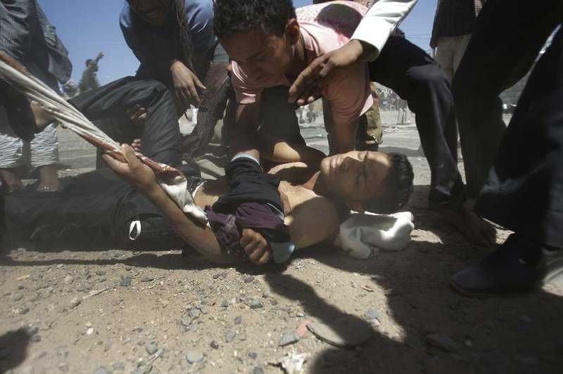 A wounded protester is carried away after clashes with security forces Tuesday in Sana, Yemen. 