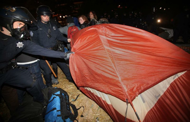 Oakland, Calif., police search tents early Tuesday as they disperse Occupy Oakland protesters from a plaza in front of City Hall where they had been camped out for about two weeks. 