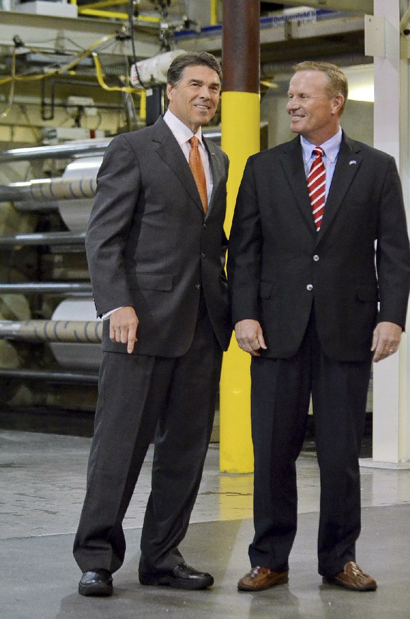 Republican presidential candidate Rick Perry (left) and Jon Mc-Clure, president of plastics company ISO Poly Films, tour a plant Tuesday in Gray Court, S.C. 