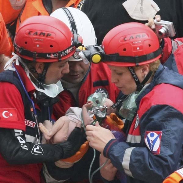 Rescuers carry 2-week-old Azra Karaduman after she was found alive Tuesday in the debris of a building in Ercis in eastern Turkey. Her mother and grandmother also were later pulled out alive. 