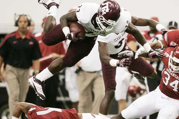 Texas A&M’s Christine Michael, leaping over Arkansas’ Tramain Thomas (5) in the first half of the Razorbacks’ 42-38 victory, rushed for 230 yards in the game and was never tackled for a loss. Of that total, 128 came in the first half. The Aggies rushed for 381 yards against Arkansas, with more than half of those yards coming in the first half. 