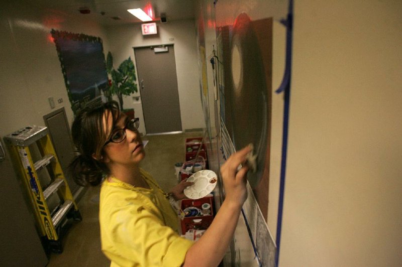 Arkansas Democrat-Gazette/RYAN MCGEENEY --10-21-2011-- 
Kayla Wilks, an inmate at the Community Corrections Center in Fayetteville, continues work on a mural painting of the Peace Ball art installation located outside the Fayetteville Town Center on Oct. 21. Inmates at the facility are encouraged to recreate various scenes from around Arkansas on interior walls throughout the facility.
