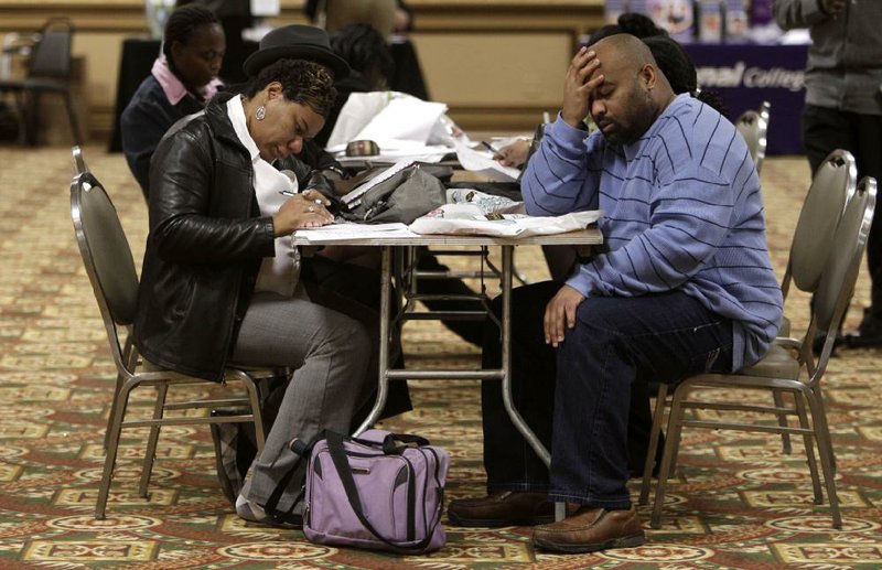 Tonya Crenshaw and Kendrick Haraalson fill out applications Wednesday at a job fair in Brook Park, Ohio. The economy created 103,000 net jobs in September, the Labor Department said.