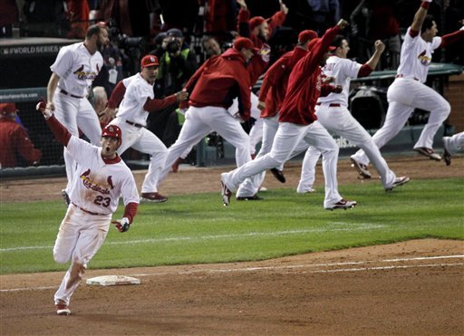 St. Louis third baseman David Freese rounds first base as his teammates celebrate behind him after his 11th-inning game-winning home run. 