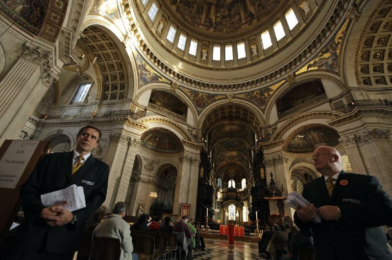 Attendants stand by with orders of service to distribute before the start of a special Eucharist service at St Paul's Cathedral in London, Friday, Oct. 28, 2011. Church and local government authorities are going to court to evict anti-capitalist protesters camped outside St. Paul's Cathedral _ though officials acknowledged Friday it could take weeks or months to get an order to remove the tent city. As the iconic church reopened after a weeklong closure triggered by the protest, the City of London Corporation said it was launching legal action on the grounds that the protest is an "unreasonable user of the highway." Scores of tents are pitched on the pedestrianized square in front of the cathedral and near a footpath alongside the building.  (AP Photo/Matt Dunham)