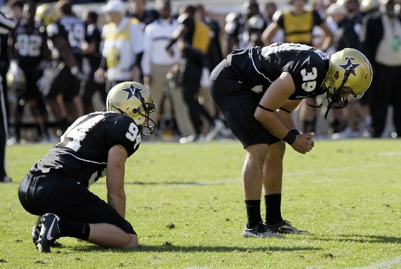 Vanderbilt kicker Carey Spear (right) and holder Richard Kent take a moment on the field after Spear missed on a 27-yard field goal attempt that would have tied Saturday’s game against Arkansas with 8 seconds left in the fourth quarter. 