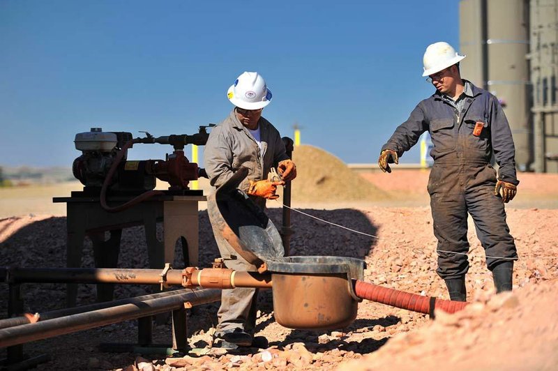 Kenny LeBaron, left, and his brother Joshua moved to North Dakota from Minnesota to take advantage of higher salaries due to an oil boom there. Here they service a gas and oil well near Watford City, North Dakota, on September 27, 2011. (Glen Stubbe/Minneapolis Star Tribune/MCT)