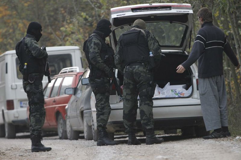 Bosnian Special police units check  personal ID of the residents on the road towards Bosnian village of  Gornja Maoca, 200 kms north from Sarajevo, on Saturday, Oct. 29, 2011. Special police units raided homes Saturday in a Bosnian village linked to the gunman who fired an automatic weapon at the U.S. Embassy in Sarajevo in what authorities called a terrorist attack. The raids came as 17 suspected associates of the shooter, all said to be members of the ultraconservative Wahhabi Muslim sect, were briefly detained in Serbia. (AP Photo/Amel Emric)