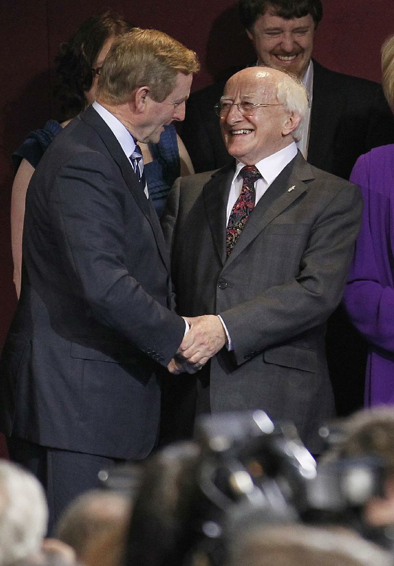 Michael D. Higgins, right, is congratulated by Irish Prime Minister Enda Kenny after being declared the 9th President of Ireland at Dublin Castle, Ireland, Saturday, Oct. 29, 2011. Michael D. Higgins, center and his wife Sabina, right, react after Higgins was declared the 9th President of Ireland at Dublin Castle, Dublin Ireland, Saturday, Oct. 29, 2011. Irish electoral officials say veteran left-wing politician Michael D. Higgins has won the presidential election with a total 56.8 percent share of votes. Saturday's result capped a two-day count of ballots to determine who would succeed Mary McAleese as Ireland's ceremonial head of state.  (AP Photo/Peter Morrison)