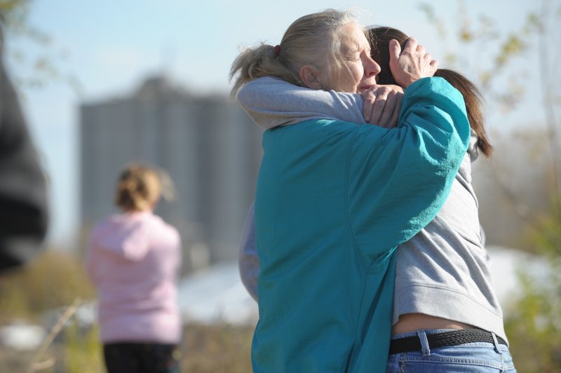Ramona Keil embraces one of her grandchildren Sunday morning in Atchison, Kan., as they wait for news about her son, Travis Keil, who is missing after Saturday’s explosion at Bartlett Grain Co. 