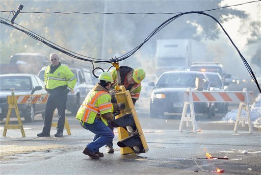 Workers from the Connecticut Department of Transportation remove a traffic signal that had fall from a downed line on Route 5 in South Windsor, Conn., on Monday, Oct. 31, 2011. 