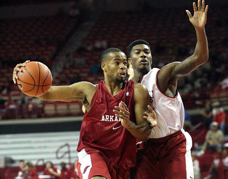 Arkansas’ Rickey Scott (left) drives against Julysses Nobles during the Red-White game on Sunday at Bud Walton Arena in Fayetteville. 