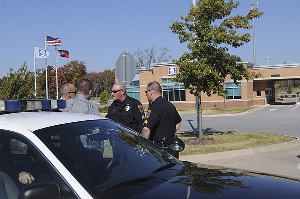 Police work the robbery of Metropolitan National Bank on Tuesday at 4201 Pleasant Crossing Parkway in Rogers.