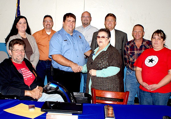 Gravette Mayor Byron Warren congratulates Margo Thomas, who was appointed by the council to fill a vacancy on the city's governing body at its meeting last Thursday night. Thomas fills the position created by the death of Bill Howard. Other city officials include city recorder/treasurer Mike von Ree, in the foreground, and council members Melissa Smith, James Denver, John Rambadt, city attorney Tom Smith, and council members Larry Stidham and Tina Crose.
