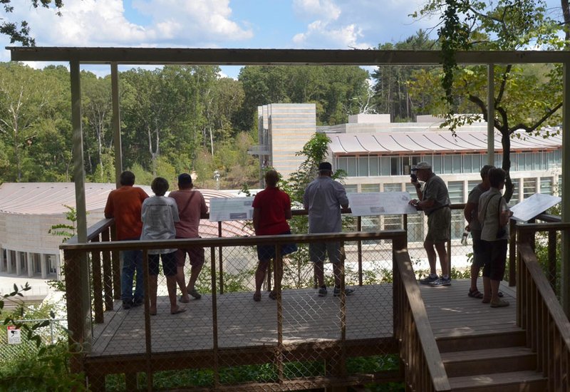 Visitors check out the progress of the Crystal Bridges Museum from the viewing platform along the Crystal Bridges trail in Bentonville Friday afternoon.