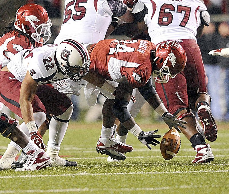  Arkansas linebacker Jerry Franklin (34) scoops up a fumble by Brandon Wilds (22) in the third quarter of the Razorbacks’ 44-28 victory over South Carolina on Saturday in Fayetteville. Arkansas, a 5 1/2 point favorite against South Carolina, has never lost under Coach Bobby Petrino when it was favored by a field goal or more. 