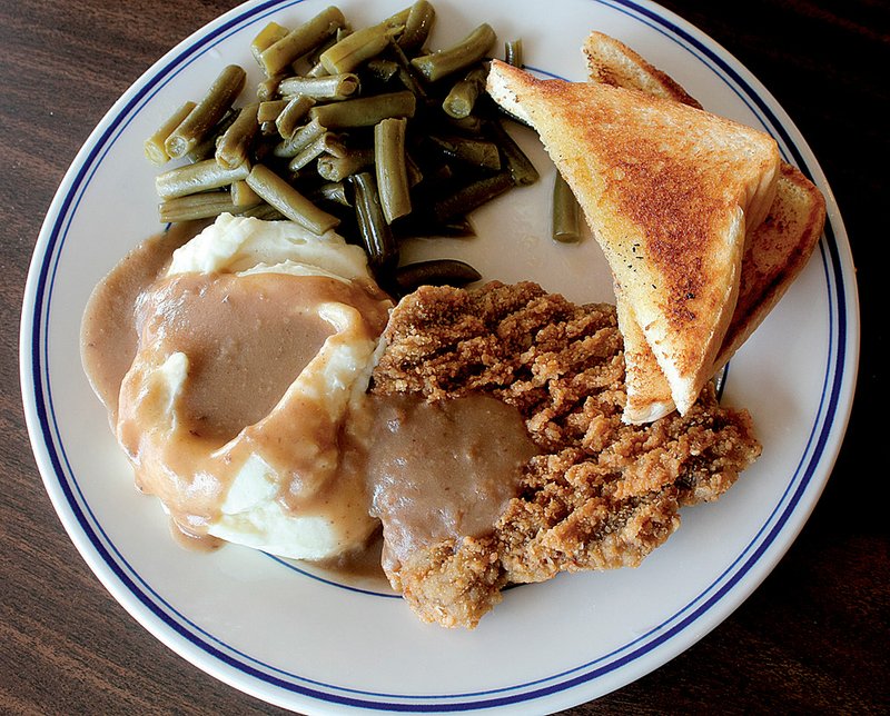 Chicken-fried steak with mashed potatoes, green beans and toast is served at the Sports Page. 