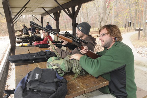 RIFLES READY Jacob Finkus, right, of Fayetteville, and his brother Ryan Finkus of Centerton, sight in their rifles for deer season last week at the Hobbs State Park-Conservation area firing range. Modern gun deer season, the state’s most popular hunting activity, opened Saturday.
