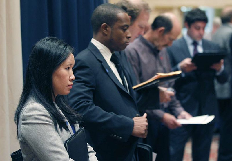  In this Nov. 14, 2011 photo, job seekers line up to speak to recruiters during a career expo in  Las Colinas, Texas. Fewer people sought unemployment benefits last week, the fourth drop in the past five weeks. The decline indicates the economy���s modest growth is reducing layoffs and may lift hiring. 