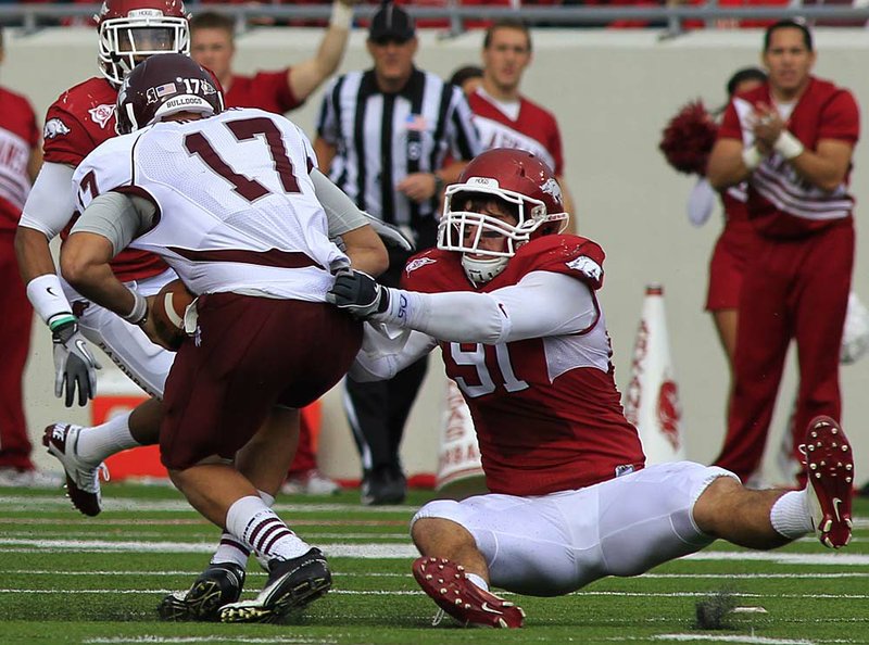 In this photo taken Sept. 3, 2011, Arkansas defensive end Jake Bequette  adjusts his helmet during the NCAA college football game against Missouri  State in Fayetteville, Ark. Arkansas expects a step up