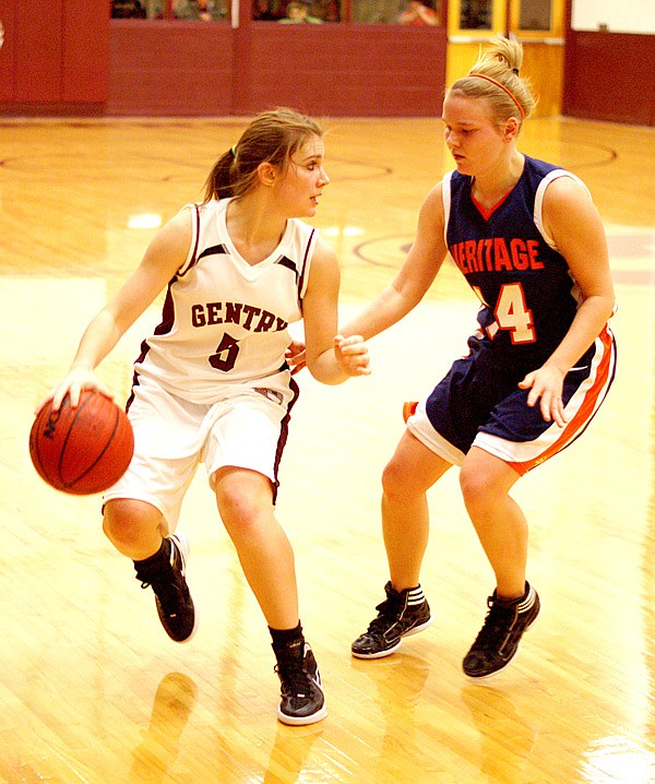 Moving the ball — Lady Pioneer Destiny Thomas moves the ball downcourt past a Rogers-Heritage defender in play on Friday night. Thomas led the Lady Pioneers with 9 points. She had 24 points against Elkins. 