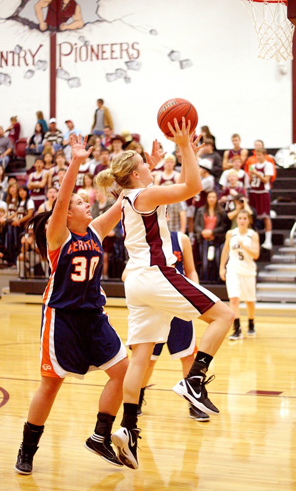 Gentry's Tara Arnold goes up for a field goal in play against Rogers-Heritage on Friday in the newly-renovated Gentry High School gymnasium.