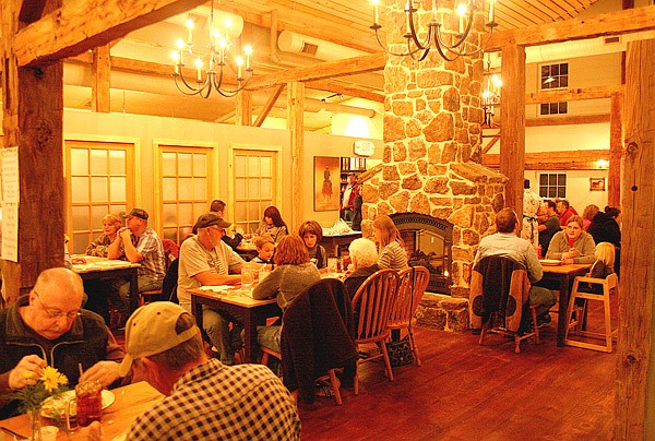 Guests enjoy an evening meal in the new Wooden Spoon Restaurant on Friday night. The new facility is built around a pre-1870 barn moved to Gentry from Michigan.