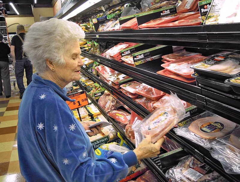  Arkansas Democrat-Gazette/PAUL QUINN -  Evelyn Harrel checks the price of a package of meat at the Edwards Food Giant in Bryant on Tuesday. She said she tries to find smaller packages of meat because she and her husband are light eaters.