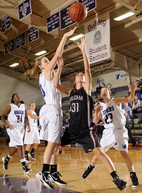 Siloam Springs’ Emery Rakestraw, center, shoots the ball under pressure from Rogers’ Sarah Grace Groves, left, and McKinzie James on Saturday during the Lady Bulldog Classic championship game in Fayetteville.