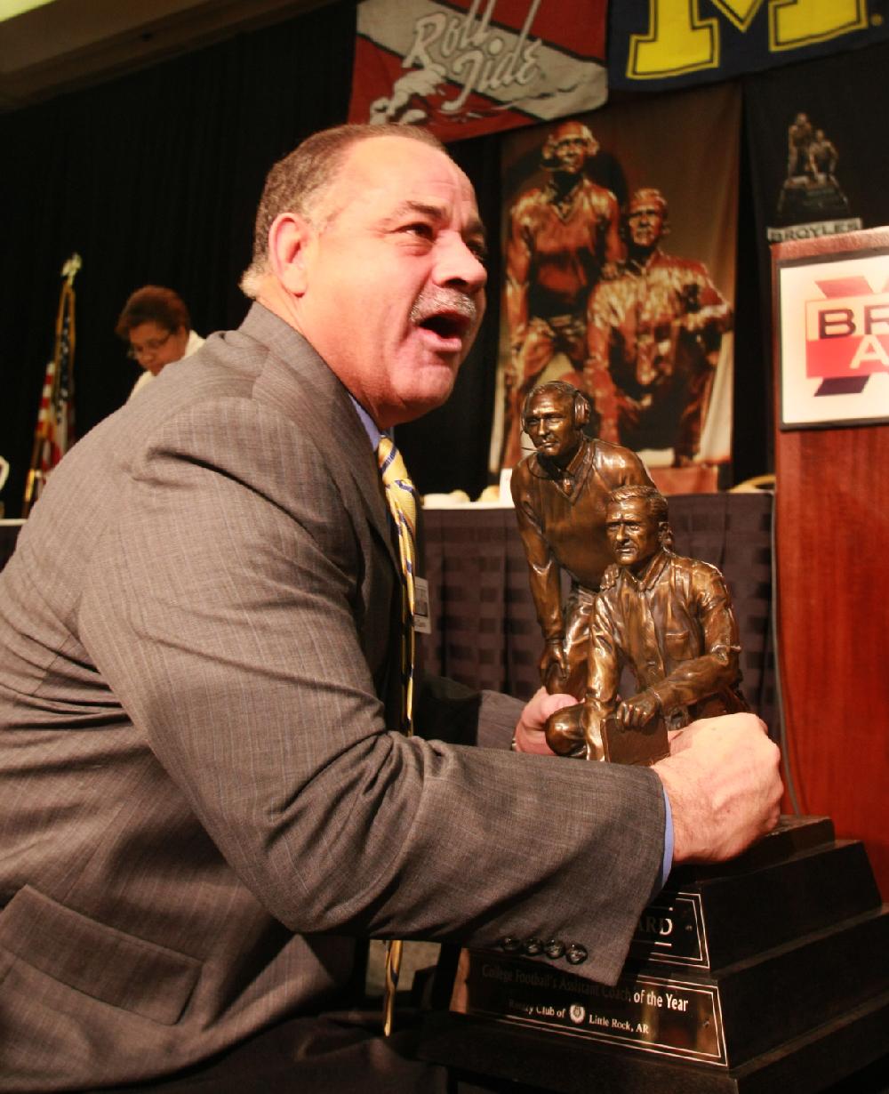 Arkansas Democrat-Gazette/RICK MCFARLAND --12/06/11-- John Chavis, Louisiana State University defensive coordinator, lifts the 50 pound-plus Broyles Award trophy after he was named Tuesday in Little Rock as the 16th recipient of the award,  given annually to the top assistant coach in college football.