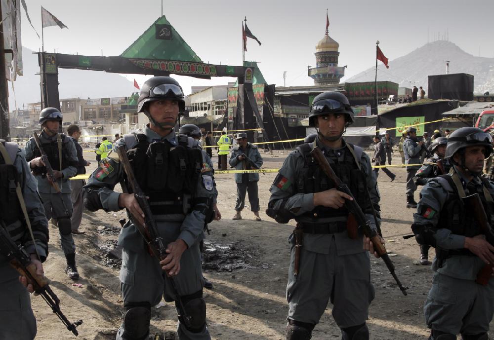 Afghan police officers stand guard at the scene of a suicide attack in Kabul, Afghanistan, Tuesday, Dec. 6, 2011. A suicide bombing tore through a crowd of Shiite worshippers marking a holy day Tuesday in the Afghan capital, the deadliest of twin attacks that killed scores of people in a rare burst of violence targeting the minority Islamic sect. (AP Photo/Musadeq Sadeq)